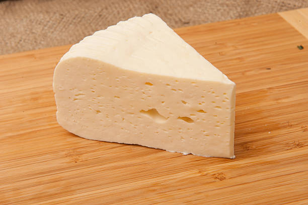 istock piece of white cheese on a wooden board 490610529