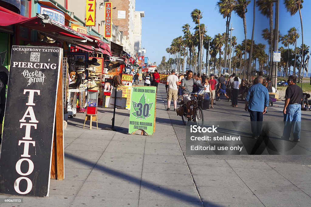 Venice Beach boardwalk, Venice, California Venice, Los Angeles, USA- May 12, 2014: A sign for medical marijuana at Venice Beach. People walking, skating and riding bikes along the boardwalk in Venice Beach. The boardwalk features stores and vendors who sell their art and merchandise. Cannabis Plant Stock Photo