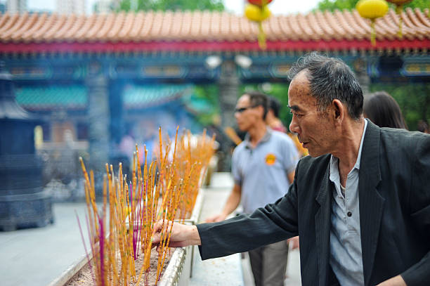 Senior man praying at Wong Tai Sin temple stock photo