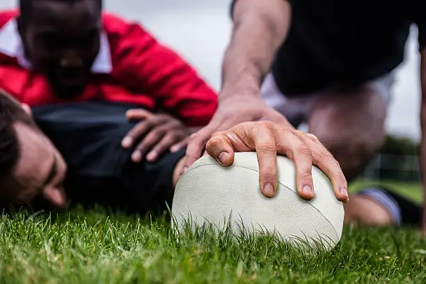 Rugby player scoring a try at the park