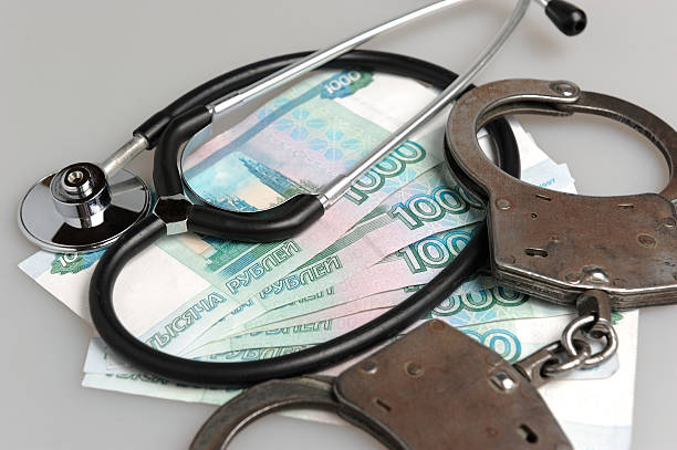 istock Stethoscope, handcuffs and money on gray 490614071