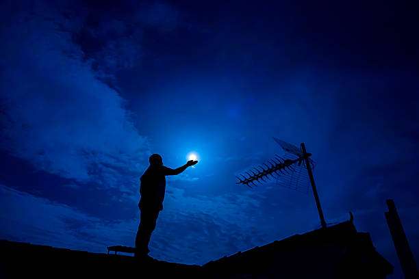 istock Man holding full moon in hand against night sky 490615722