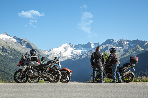 Gerlos, Austria - July 10, 2015: The new BMW GS1200 built from 2013 onwards liquid cooled version color red. incl Touratech guards and navigation system Tom Tom..also an older version of the GS on the right and Harley Davidson behind the BMW on the left.