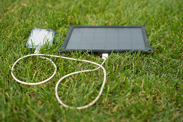 telefone celular alimentação com energia solar-carregador - plug adapter charging mobile phone battery charger - fotografias e filmes do acervo