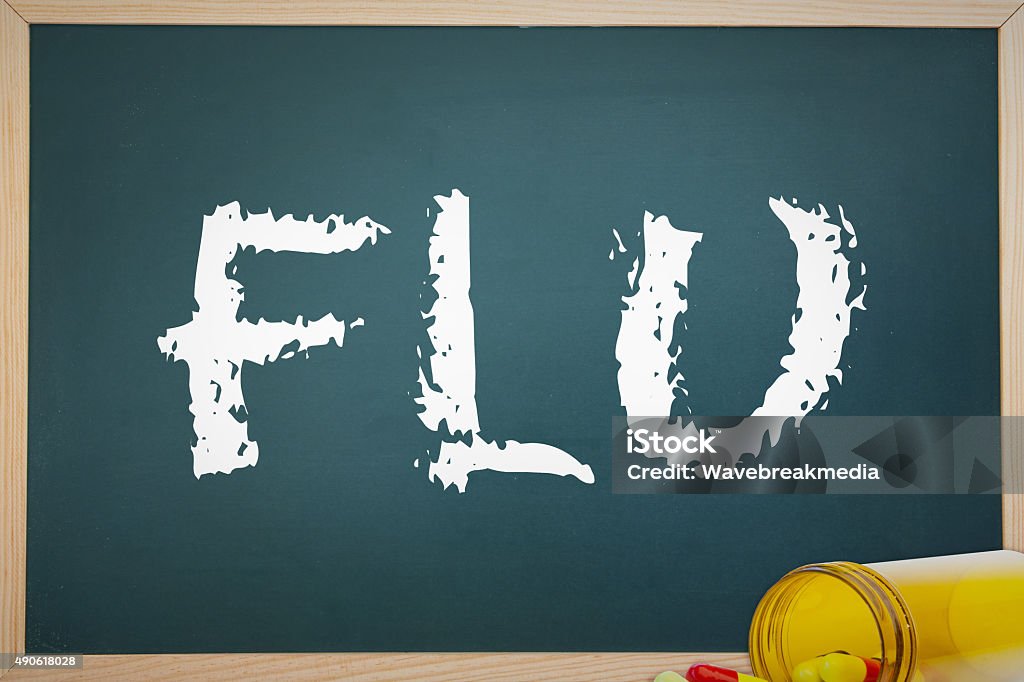 Flu against spilled pills The word flu and chalkboard against spilled pills 2015 Stock Photo