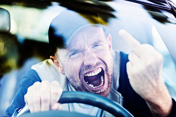 istock Road rage: furious male driver makes obscene gesture, yelling 490618216