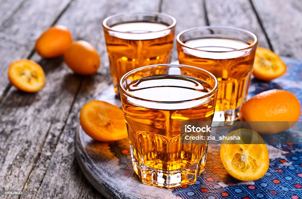 Liquid orange Liquid orange color in a glass container on a wooden surface 2015 Stock Photo