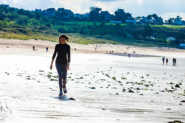 istock Woman running on water's edge on the beach 490632100