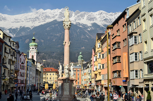 Innsbruck, Austria - March 2nd 2011: Crowd of unidentified people at Maria-Theresien-street with Mariensaeule (Anna-Saeule) Spitalskirche (left) and city-tower (right)