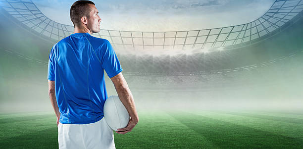 istock Composite image of rugby player looking away while holding ball 490632856
