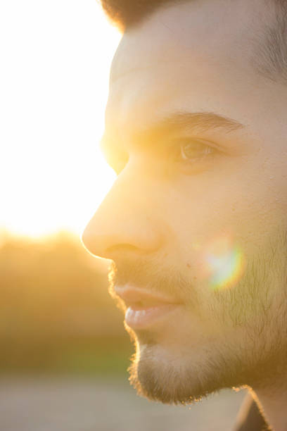 istock face close up of young men, strong sun light 490633744