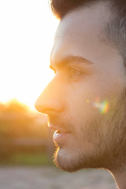 istock face close up of young men, strong sun light 490633838