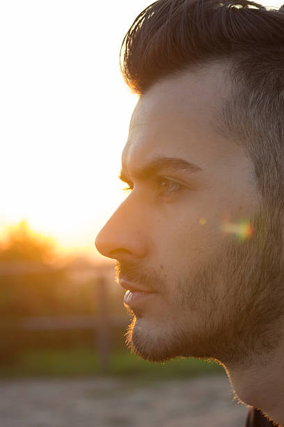 istock face close up of young men, strong sun light 490634002