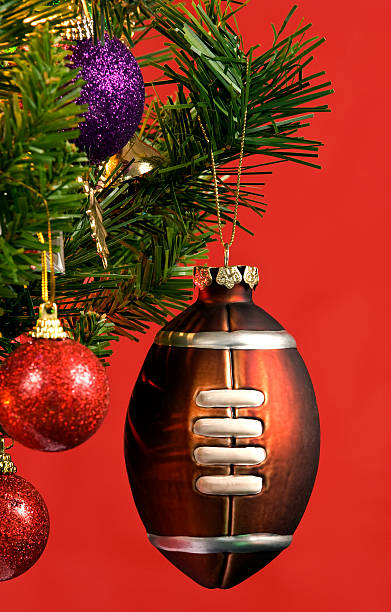 American Football Christmas Ornament On Red Background Vertical shot of an American football Christmas ornament on red background inflatable soccer balls stock pictures, royalty-free photos & images