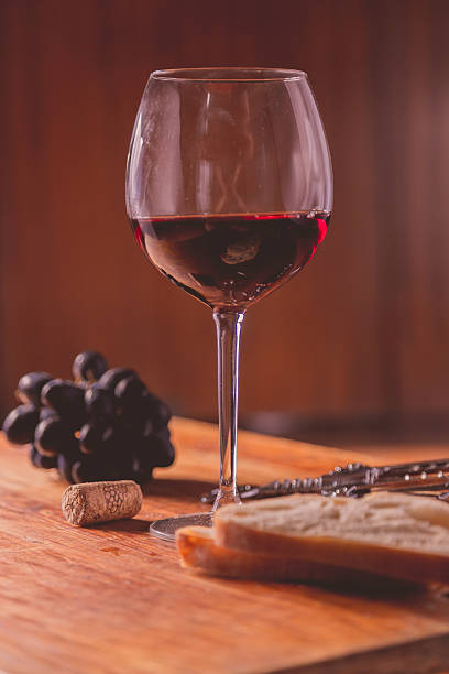 istock Red wine against wooden background 490635658