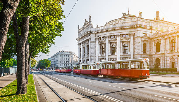 Wiener Ringstrasse with Burgtheater and tram at sunrise, Vienna, Austria Famous Wiener Ringstrasse with historic Burgtheater (Imperial Court Theatre) and traditional red electric tram at sunrise with retro vintage Instagram style filter effect in Vienna, Austria. austrian culture photos stock pictures, royalty-free photos & images