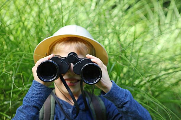 istock Child in Safari Hat Looking Through Big Binoculars Outdoors 490639466