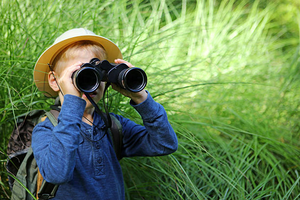istock Safari Boy in High Green Grass Looking Through Big Binoculars 490639518