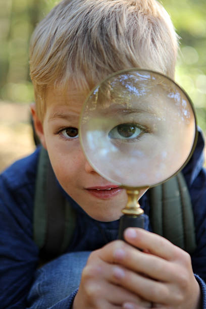 istock Boy Holding a Magnifying Glass Looking Towards the Camera 490639632