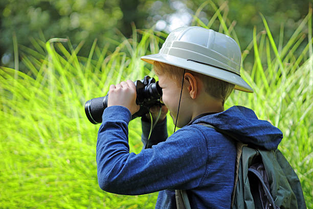 istock Safari Boy Looking Through Big Binoculars Outdoors 490639670