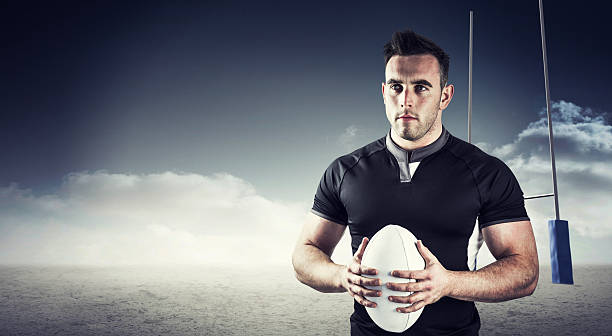 istock Composite image of tough rugby player holding ball 490640788