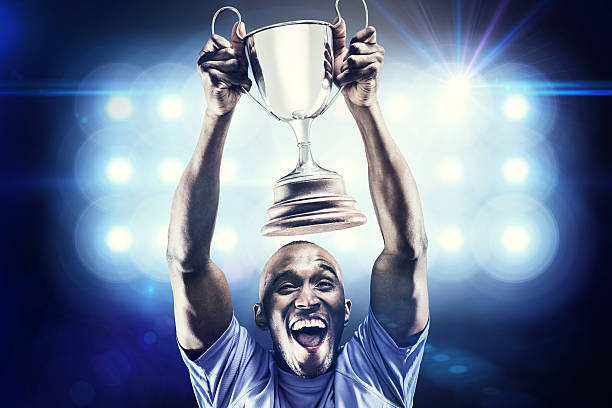 istock Composite image of happy athlete cheering while holding trophy 490642616