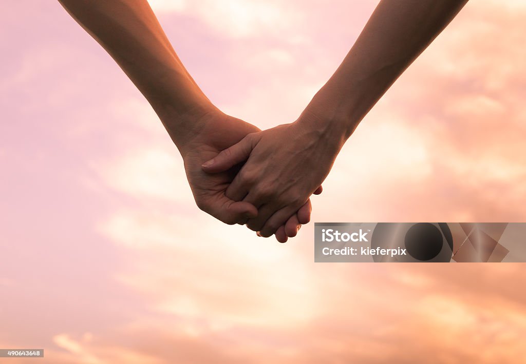 Holding hands Couple holding hands against the sunset. Holding Hands Stock Photo