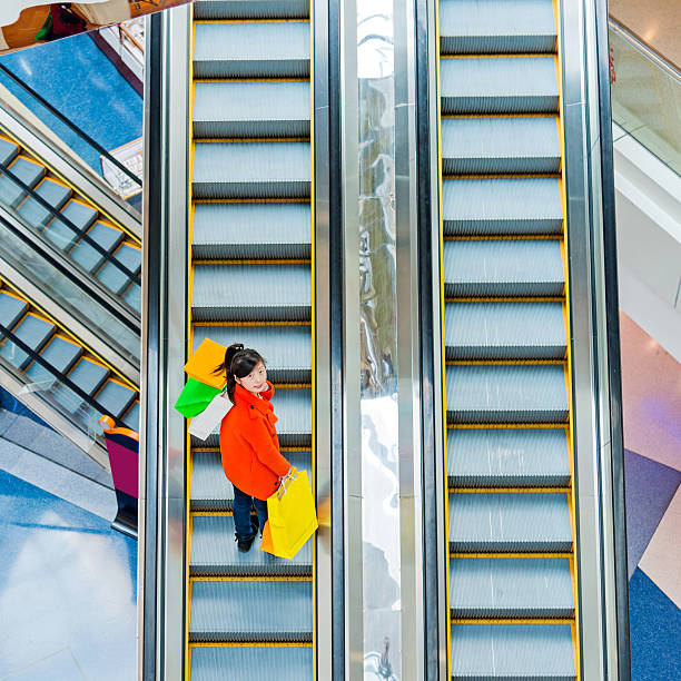 istock Female shopper standing on escalator 490643894