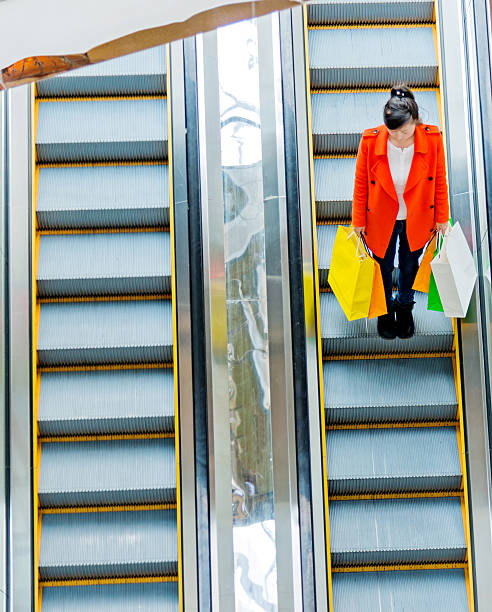 istock Female shopper standing on escalator 490643938
