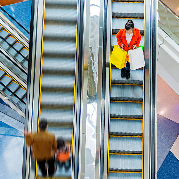 Female shopper standing on escalator