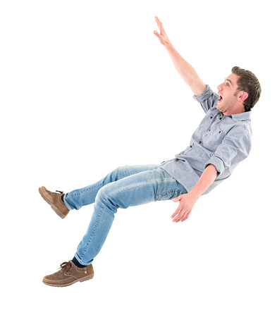 Casual man falling and looking worried  - isolated over a white background