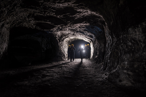 Group of men in a dark mine underground - mining concepts