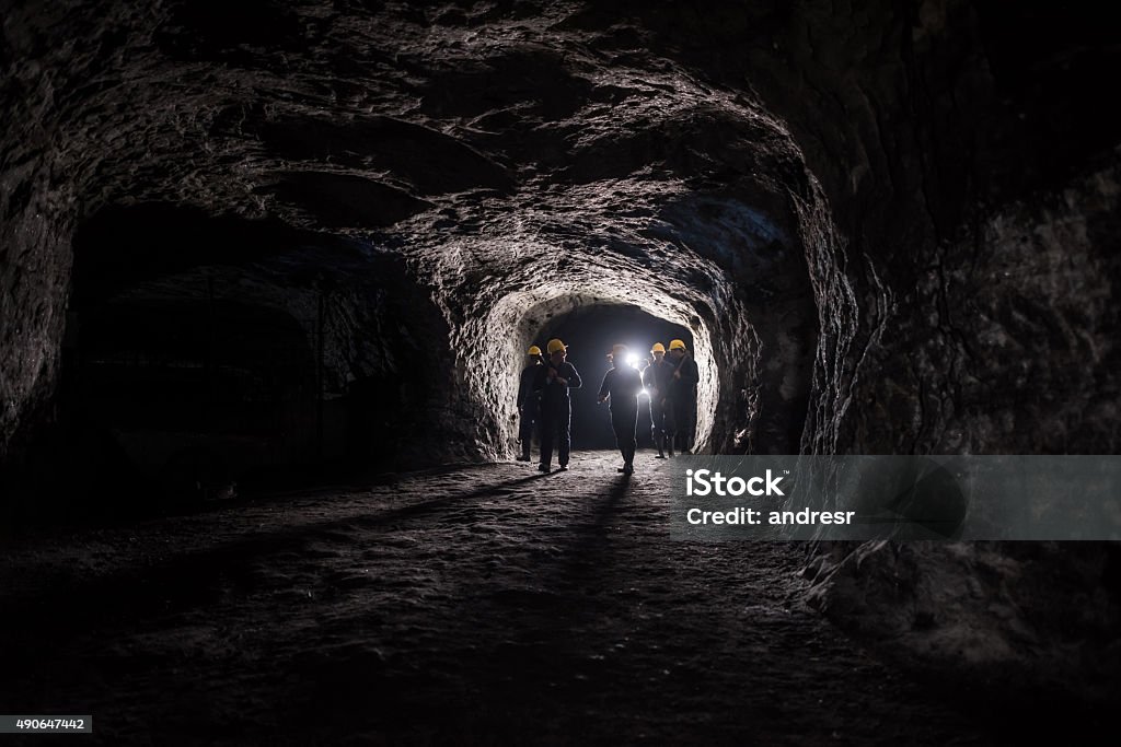 Group of men in a mine Group of men in a dark mine underground - mining concepts Mining - Natural Resources Stock Photo