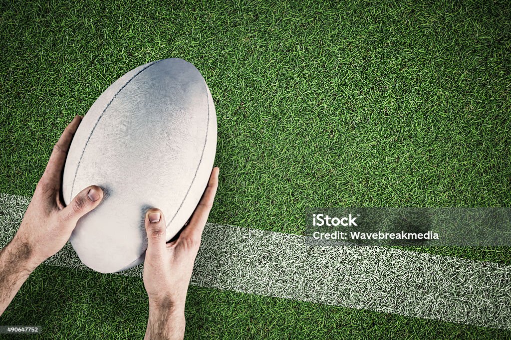 Composite image of rugby player scoring try A rugby player posing a rugby ball against pitch with line Rugby Ball Stock Photo