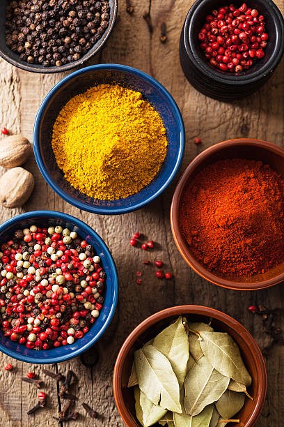 istock spices in bowls: pink black pepper, paprika powder, curry 490651527