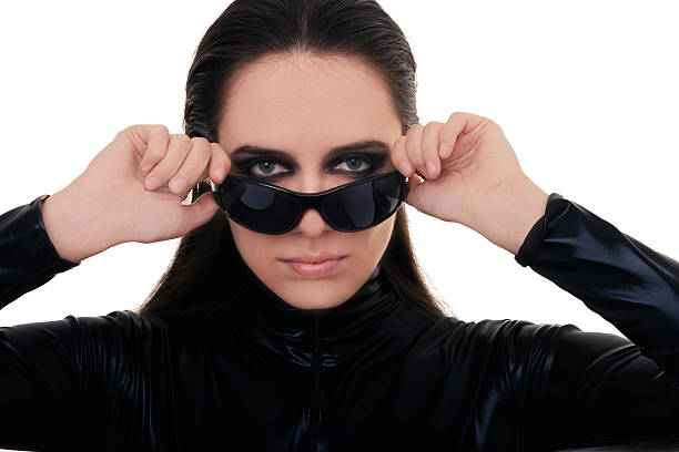 Young woman with a scarf wrapped around her head and wearing sunglasses.