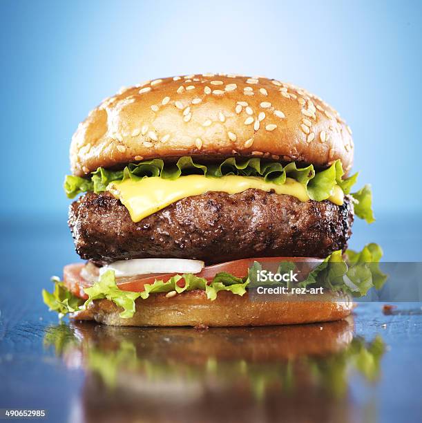 Burger With Melted Cheese And Sesame Bun Stock Photo - Download Image Now - Backgrounds, Beef, Blue