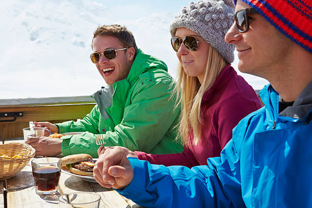 gruppe von freunden, genießen eine mahlzeit im café in ski resort - apres ski ski restaurant mountain stock-fotos und bilder