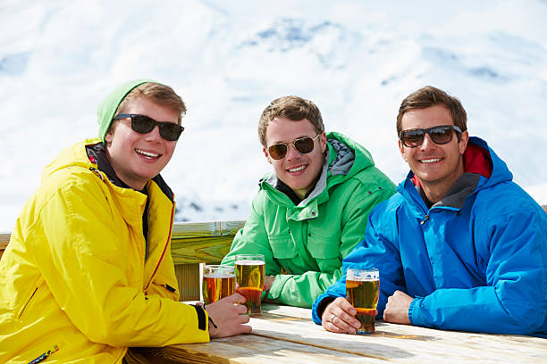 gruppo di giovani uomini godersi un drink a ski resort - cold discussion outdoors snow foto e immagini stock