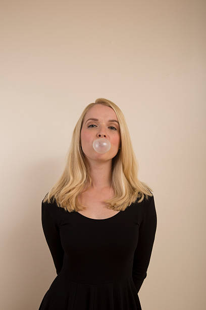 soplando burbujas - chewing gum women bubble blowing fotografías e imágenes de stock