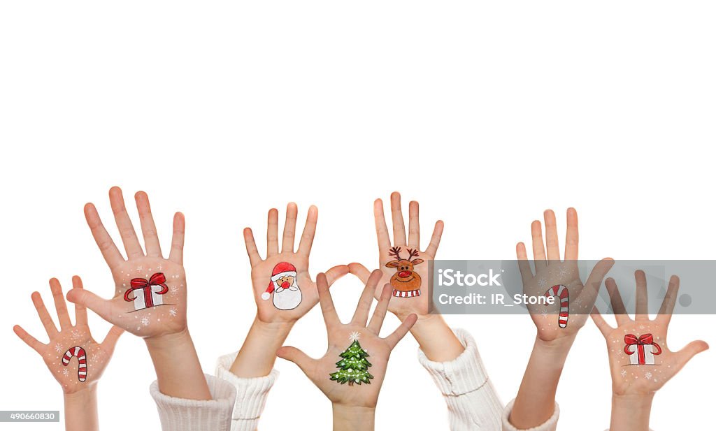 Raising up children's hands and painted symbols. Santa, snowman etc. Christmas background with raising up hands and painted symbols: Santa, christmas tree, snow man, reindeer and Christmas present 2015 Stock Photo