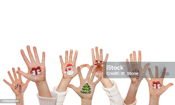 Raising Up Childrens Hands And Painted Symbols Santa Snowman Etc Stock Photo - Download Image Now