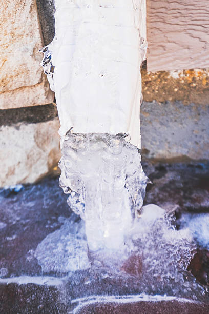 downspout z wodą obrócona do lodu podczas śnieżyca - melting ice icicle leaking zdjęcia i obrazy z banku zdjęć