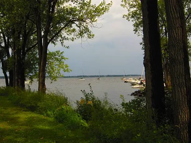 Lake Champlain, Plattsburgh, New York, Boat Basin, with trees, water sky and sailboats.