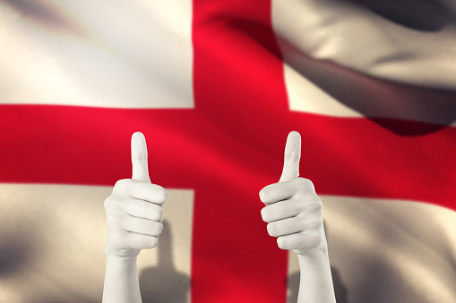 Businesswomans hands showing thumbs up against england flag against white background
