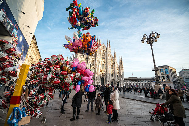 Milan, Italy  - December 25, 2014: Christmas holidays on Piazza del Duomo, Milan. People having fun, buying gifts on Christmas market. Vendors selling balloons 