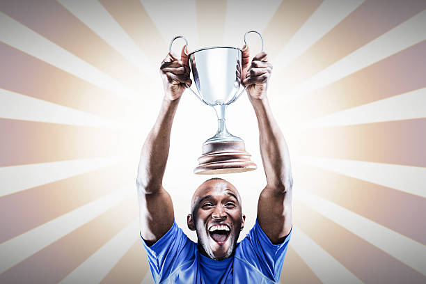 istock Composite image of happy athlete cheering while holding trophy 490666268
