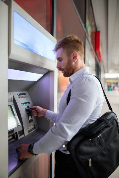istock Young businessman using cash machine in the city. 490667306