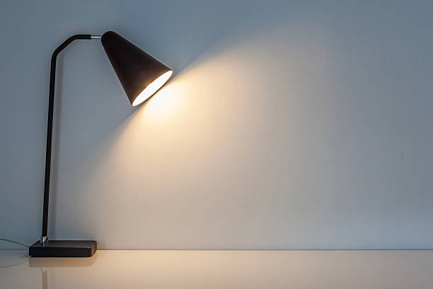 istock The modern desk lamp illuminate on the wall background. 490667914