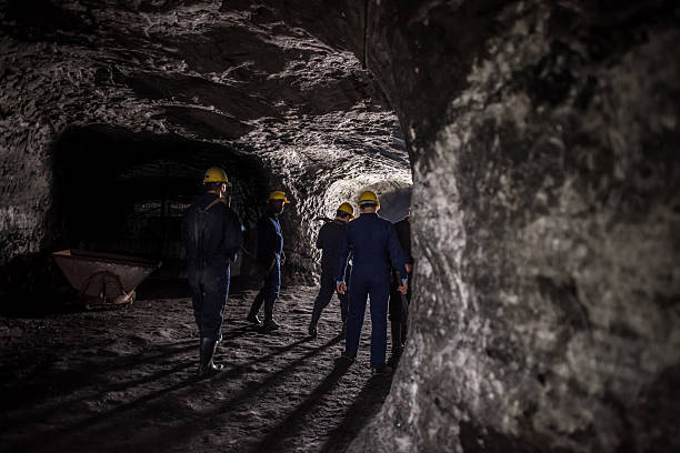 Group of miners working at the mine and walking through a tunnel